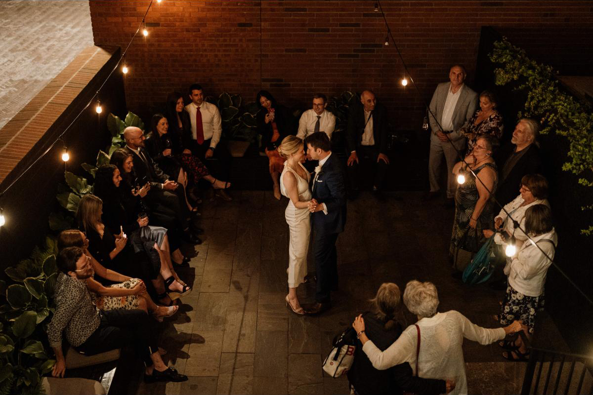 Couple dancing in an open courtyard at night during their reception