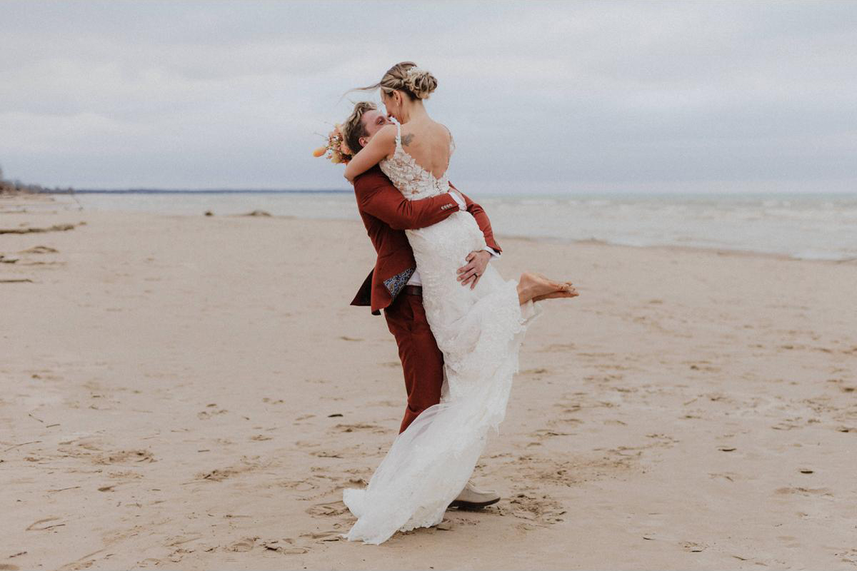 A couple embracing on the beach on their wedding day