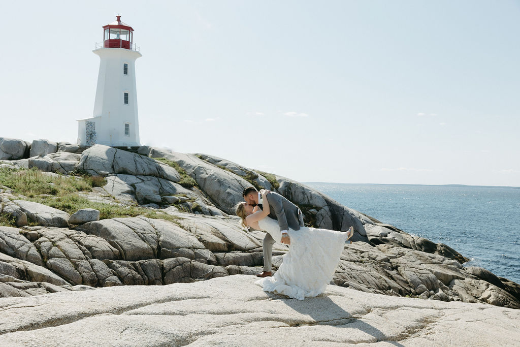 Bride and groom share a dip-kiss at the lighthouse