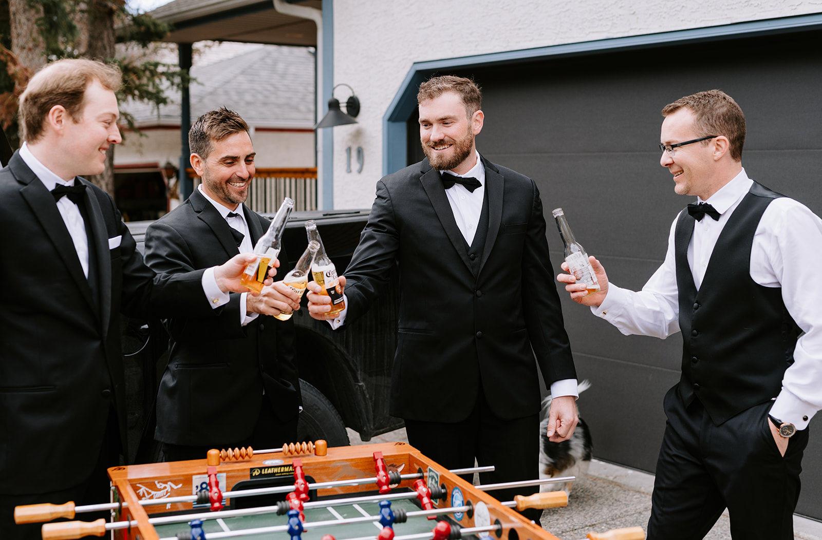 Groom and groomsmen play foosball on wedding morning