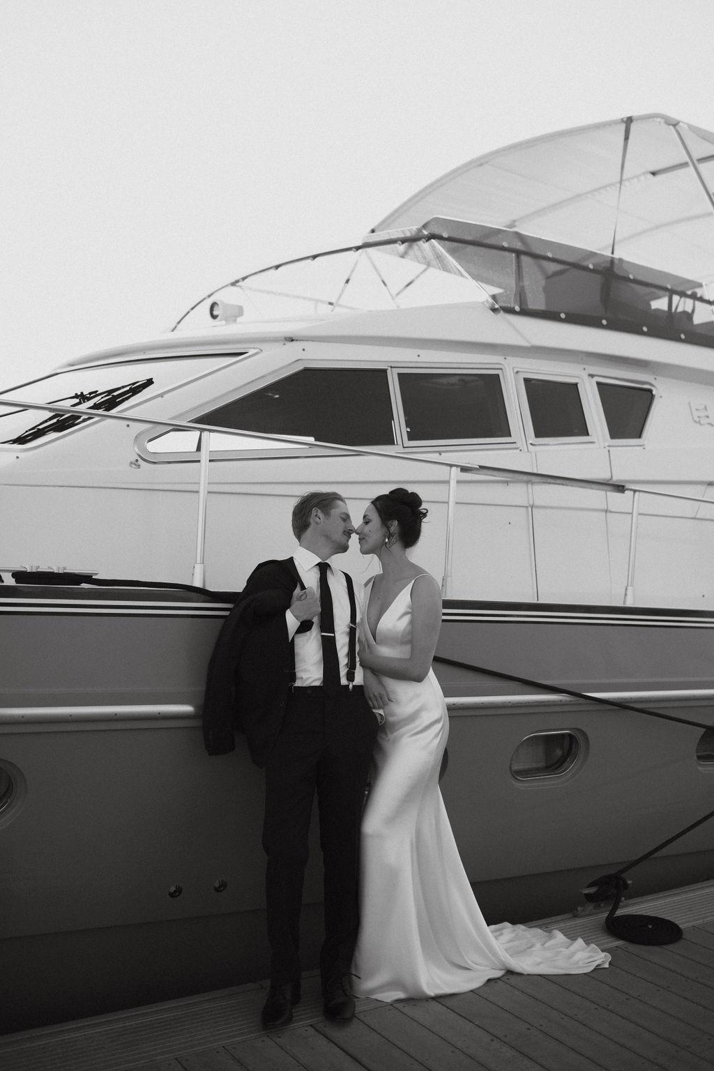 Couple posing in front of boat at Fox Harb'r resort, Nova Scotia