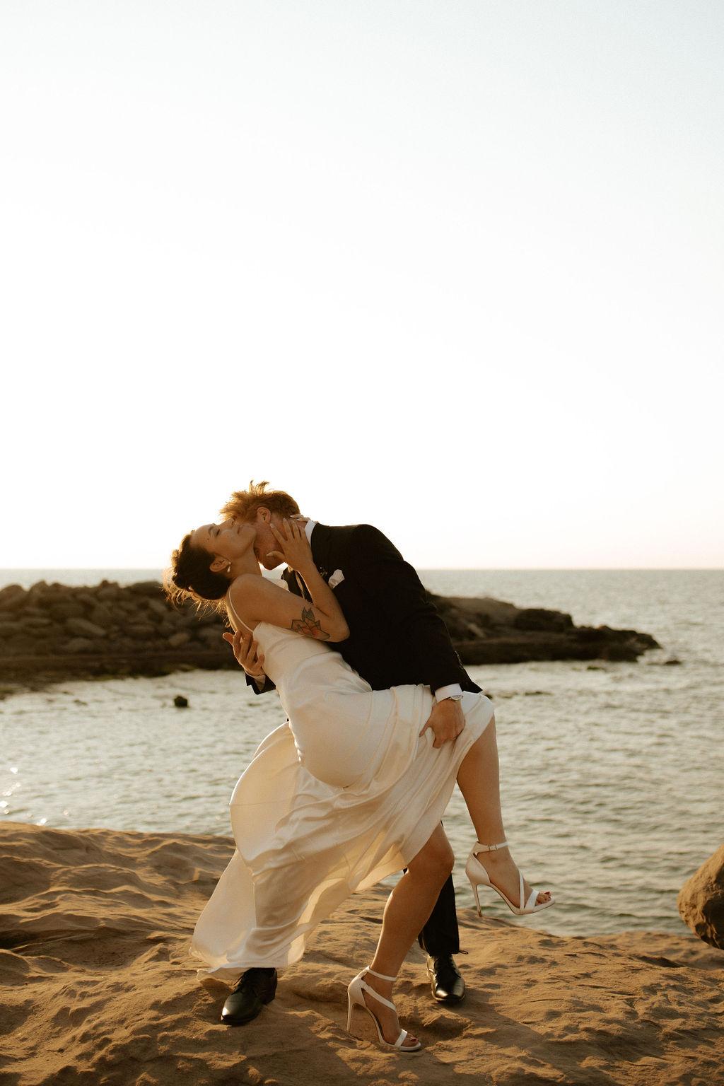 Bride and groom embracing after their wedding ceremony along the Northumberland Strait at Fox Harb'r, Nova Scotia