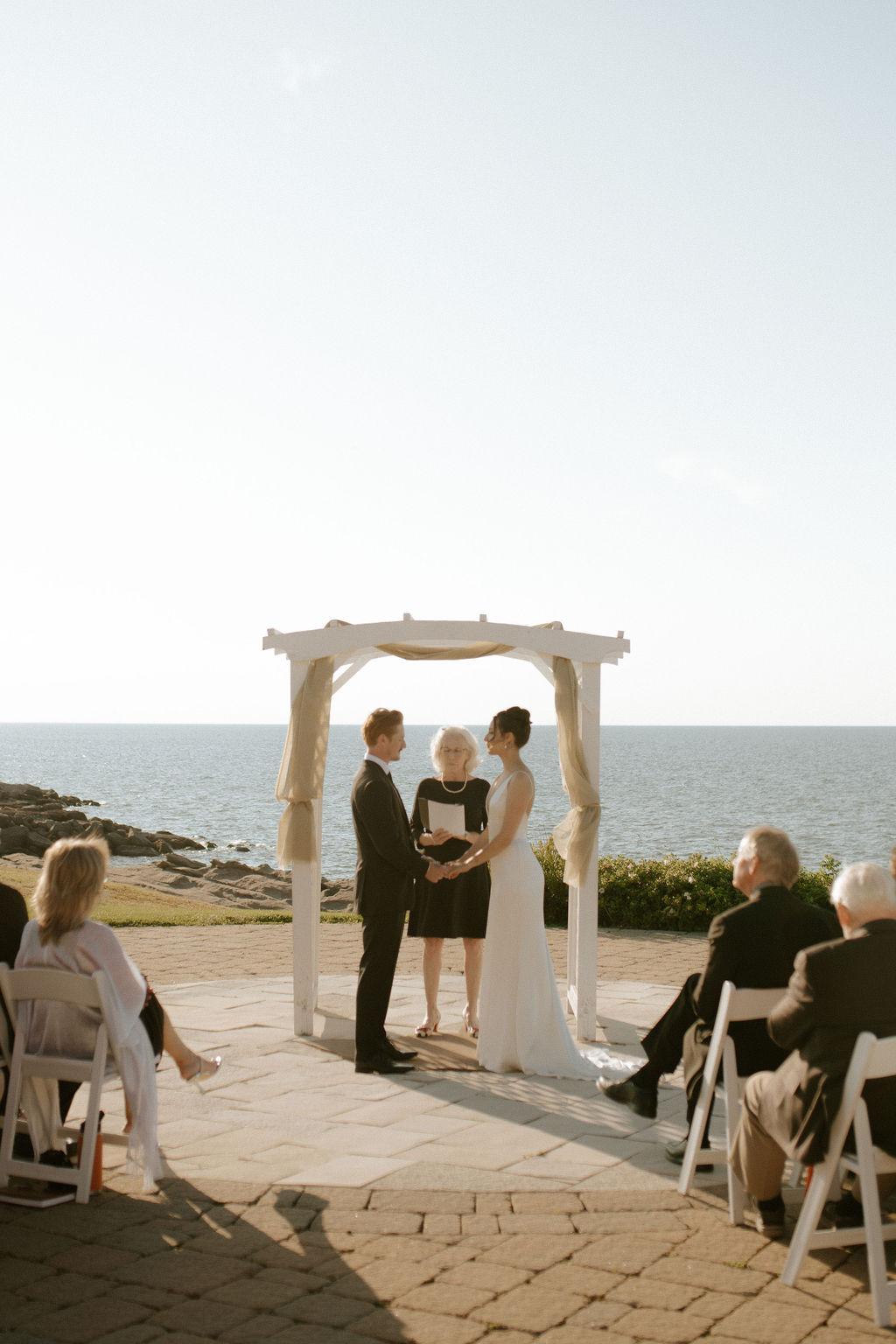 Bride and groom during wedding ceremony along the Northumberland Strait at Fox Harb'r, Nova Scotia