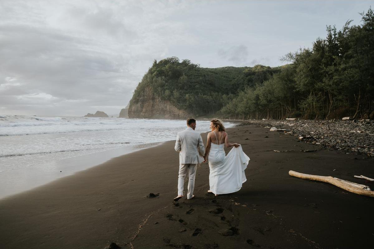 Bride and groom walking down beach