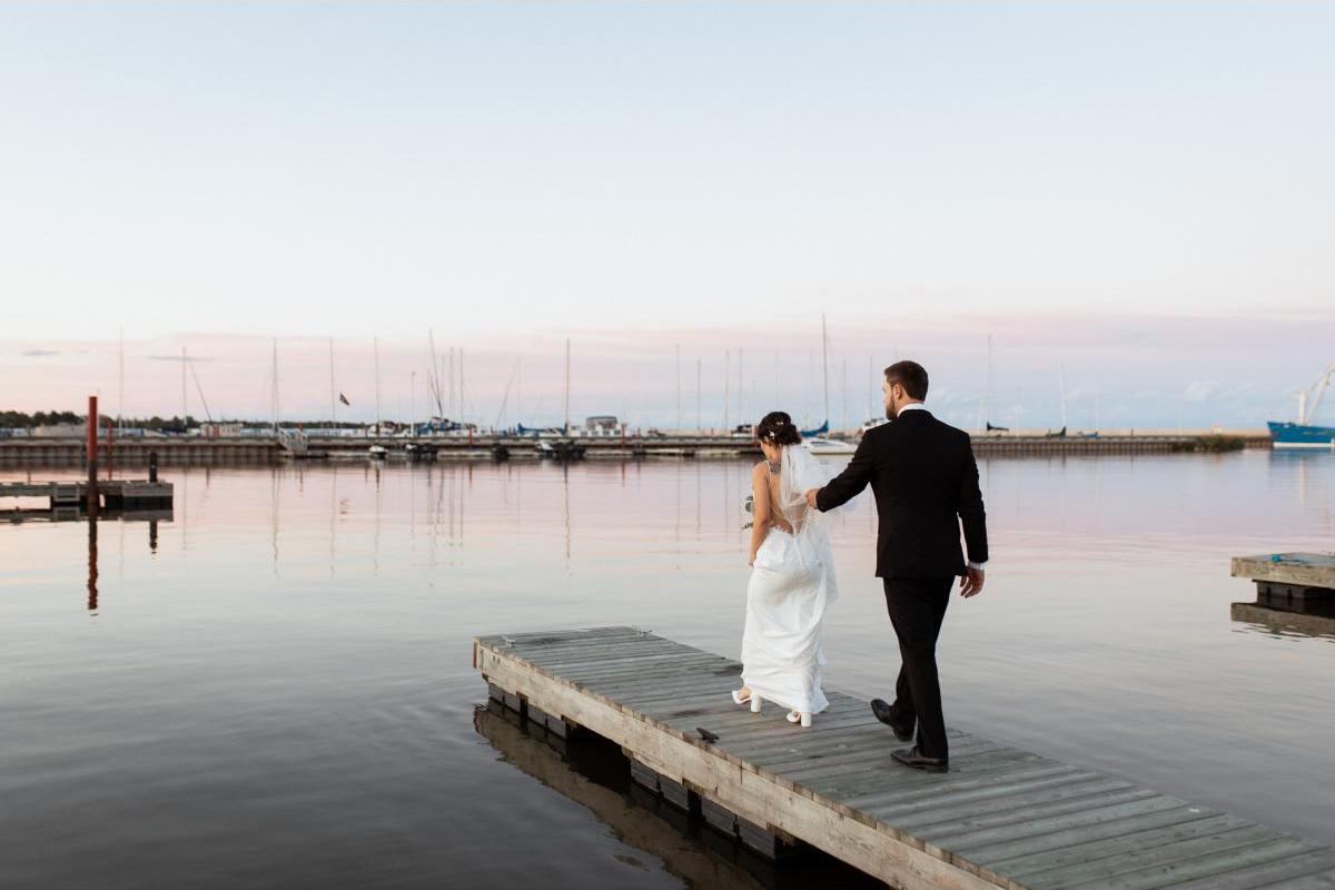 Bride and groom walking on dock in gimli