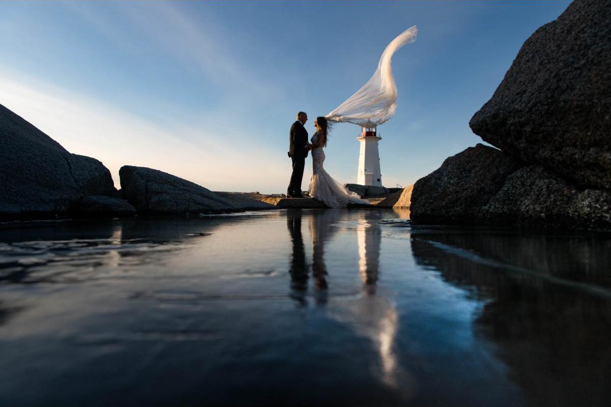 Bride and groom in front of lighthouse in Nova Scotia