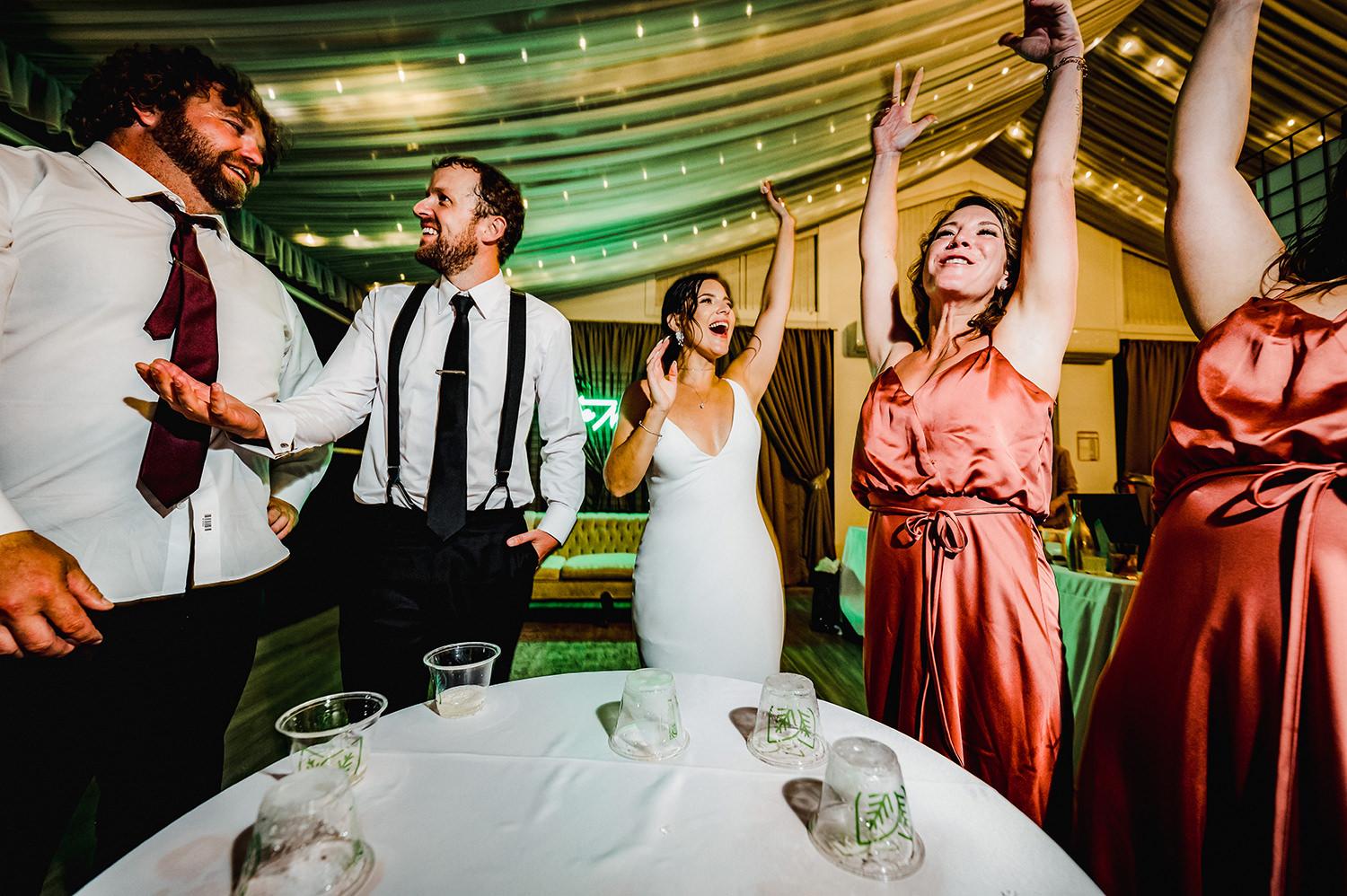 Wedding party playing beer pong at wedding reception by Winnipeg photographers Black & Gold Photography