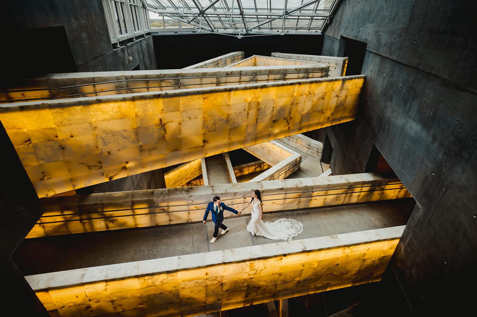 Bride and groom walking across the alabaster rampways at the Canadian Museum for Human Rights in Winnipeg, MB